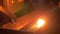 Glowing detail from molten metal moving on conveyor line at metallurgy plant