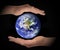 Glowing earth globe in hands on black background, environment concept, elements of this image furnished by NASA