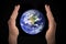 Glowing earth globe in hands on black, environment concept - elements of this image furnished by NASA