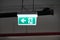 Glowing Emergency exit sign with left arrow at a building. Safety first concept. Copy space wallpaper. Exit signs with light in a
