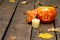 Glowing evil Halloween pumpkin on wooden old floor with dry autumn leaves