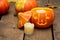 Glowing evil Halloween pumpkin on wooden old floor with dry autumn leaves