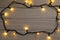 Glowing festive lights on wooden background, top view. Space for text