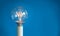 Glowing filament of an industrial vintage  illuminated light bulb, idea concept on a blue background