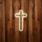 Glowing holy cross on wooden background