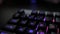 Glowing keyboard hackier style glittering at the night workplace with different light colors
