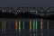 Glowing lanterns are reflected in the dark waters of the river and create glowing paths. Paths of light on black water.