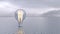 Glowing light bulb on the surface of a calm sea or ocean. Alternative renewable energy source. Production of electricity from