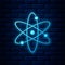 Glowing neon Atom icon isolated on brick wall background. Symbol of science, education, nuclear physics, scientific