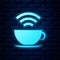 Glowing neon Cup of coffee shop with free wifi zone icon isolated on brick wall background. Internet connection placard