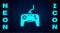Glowing neon Gamepad icon isolated on brick wall background. Game controller. Vector