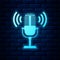 Glowing neon Microphone icon isolated on brick wall background. On air radio mic microphone. Speaker sign. Vector