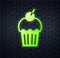 Glowing neon Muffin icon isolated on brick wall background. Vector