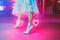 Glowing neon shaped hearts lights with slender model legs and shoes - generative AI