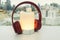 Glowing portable Bluetooth speaker in bright yellow color with cute pink wireless headphones for pairing to listen to music