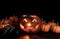 Glowing scary pumpkin decorations and hand in dark background