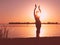 Glowing silhouette of slim woman with hands up in the air illuminated with sunshine