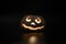 Glowing smiling face Halloween pumpkin, candle holder, isolated on night dark black background.