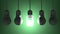 Glowing spiral light bulb among dead tungsten ones hanging on green