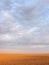 Glowing tilled patterned field under pink and blue sky