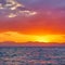 Glowing yellow red sky with clouds aloft the sea at sunset