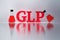 GLP red letters and laboratory flasks reflected on the white surface.