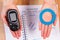 Glucometer and blue circle in hand, symbol of diabetic, world diabetes day