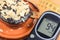 Glucometer for checking sugar level and fresh chocolate muffins. Diabetes and delicious dessert for diabetics