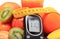 Glucometer, fresh fruits with tape measure and glass of juice