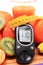 Glucometer, fresh fruits with tape measure and glass of juice