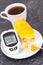Glucometer with high sugar level  creamy fruit cake with jelly and cup of coffee. Nutrition during diabetes. Delicious dessert for