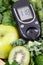 Glucometer with result sugar level and green natural fruits with vegetables. Body detox and healthy nutrition during diabetes