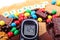 Glucometer, sweets and cane brown sugar with word diabetes, unhealthy food