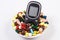 Glucose meter with heap of medical pills and capsules, diabetes, health care concept