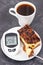 Glucose meter with high and bad result sugar level and fresh baked cheesecake with coffee. Dieting during diabetes