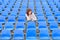 Glum woman sitting in spectator seating