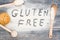 Gluten free word written on flour and wooden table.