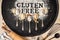 Gluten free written in flour on vintage baking sheet and spoons of various gluten free flour almond flour, buckwheat