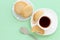 Glutenfree homemade oatmeal cookies cup of tea or coffee espresso on pastel green background. Mint color background. Top view
