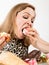 Glutton woman eating cupcakes with frenzy after long diet