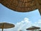 glWicker beach umbrellas under blue sky with clouds, Halkidiki Greece