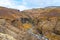 Glymur waterfall in Iceland gorge behind fall cutting through colorful autumn landscape