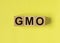 GMO word on wooden dices on yellow background