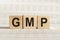 GMP abbreviation - good manufacturing practice, on wooden cubes on a light background