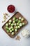 Gnarly garlic brussels ingredients, on white textured background, top view