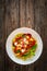 Gnocchi alla sorrentina - gnocchi with melted mozzarella cheese in tomato sauce and Parmigiano Reggiano on wooden table