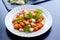 Gnocchi alla Sorrentina in tomato sauce with green fresh basil and mozzarella balls served on a plate