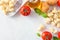 Gnocchi meal ingredients, tomatoes, olive oil, potatoes and basil, above view, corner border on white marble