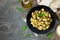 Gnocchi with pesto sauce, top view scene over dark stone