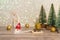 A gnome in a red hat brought a golden gift on a sleigh. Winter background Christmas trees in sparkles and a deer. Happy